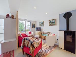 a living room with a red couch and a fireplace at Apartment Ty PJP by Interhome in Névez +29 photos