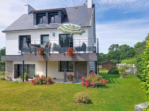 a house with a balcony with an umbrella at Apartment Ty PJP by Interhome in Névez