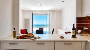 a kitchen with a table with two glasses of wine at SkyMare - Beachfront Sea View Apartment in Porto San Giorgio