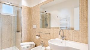 a bathroom with a sink and a toilet and a mirror at SkyMare - Beachfront Sea View Apartment in Porto San Giorgio