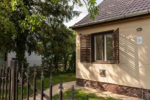 a house with a fence in front of it at Flóra Vendégház Balatonvilágos in Balatonvilágos