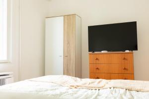 a bedroom with a dresser with a television on it at Flóra Vendégház Balatonvilágos in Balatonvilágos