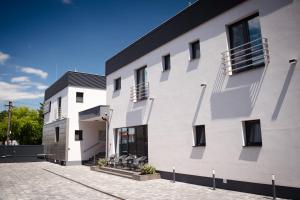 a white building with a black roof at LAMBERT Residences in Lučenec