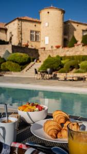 a table with a plate of food and a bowl of bread at Château de Cachard in Boffres