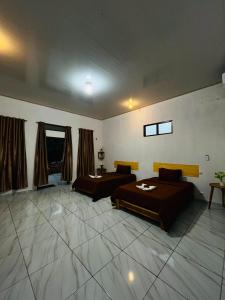 a large room with two beds and a table at Lomba Oen bungalow in Nembrala