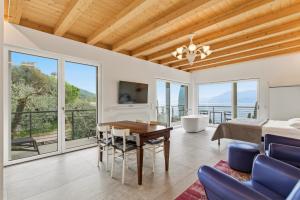 a living room with a dining table and a view of the ocean at Pai 521 openspace in Torri del Benaco