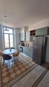 a kitchen with a table and a refrigerator at Casa Tatta - Luino centro in Luino +8 photos