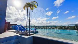 a swimming pool with blue chairs and a palm tree at Makani Beach Campas - Praia de Tamandaré in Tamandaré +20 photos