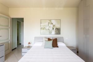 a bedroom with a large white bed with two pillows at Latte & Menta by Garda FeWo in Gardone Riviera