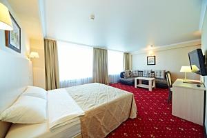 une chambre d'hôtel avec un lit et un salon dans l'établissement Bryansk Hotel, à Briansk