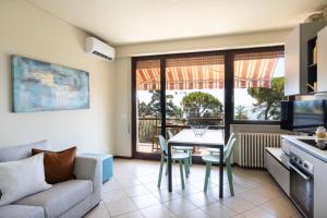 a living room with a table and a couch at Latte & Menta by Garda FeWo in Gardone Riviera