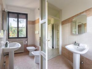 a bathroom with two sinks and a toilet at Latte & Menta by Garda FeWo in Gardone Riviera