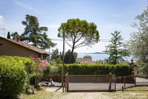 a gate to a house with a view of the water at Latte & Menta by Garda FeWo in Gardone Riviera