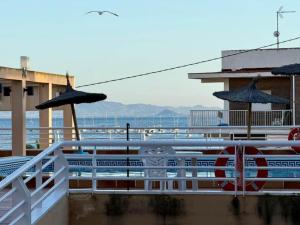 a train on a pier with umbrellas and the ocean at Aguas Salinas A3 Studio in San Pedro del Pinatar