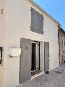 a white building with two doors and a window at Le Petit Nid de Venelles in Venelles +2 photos
