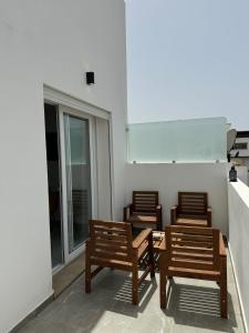 three wooden chairs and a table in a room at Charming apt with terrace in Kenitra