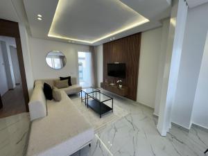 a living room with a couch and a television at Charming apt with terrace in Kenitra