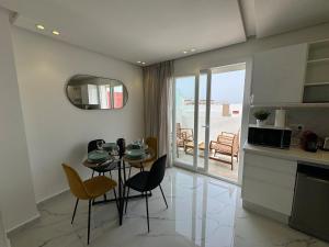 a kitchen and dining room with a table and chairs at Charming apt with terrace in Kenitra