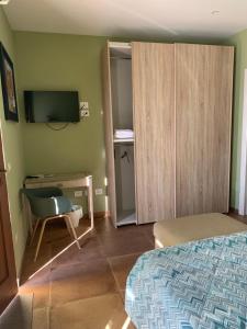 a bedroom with a bed and a desk and a television at Green B&B Urbino Cá del vento in Urbino