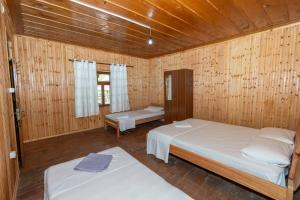 a bedroom with two beds in a wooden room at Hotel Shen Klementi in Vermosh