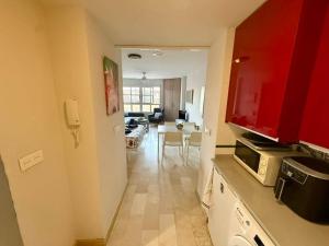 a kitchen with red cabinets and a living room at Aguas Salinas A3 Studio in San Pedro del Pinatar