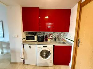 a kitchen with red cabinets and a washing machine at Aguas Salinas A3 Studio in San Pedro del Pinatar