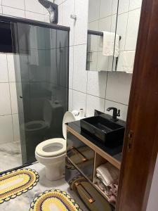 a bathroom with a black sink and a toilet at Pousada Dona Maria in Pomerode