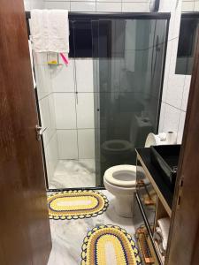 a bathroom with a toilet and a glass shower at Pousada Dona Maria in Pomerode +7 photos