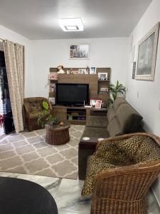 a living room with a couch and a television at Pousada Dona Maria in Pomerode