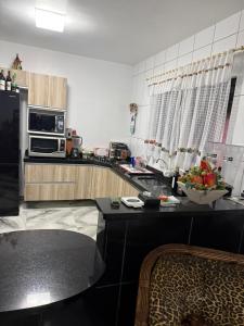 a kitchen with a black counter top and a black refrigerator at Pousada Dona Maria in Pomerode
