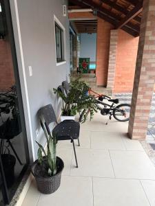 a patio with two chairs and a plant at Pousada Dona Maria in Pomerode