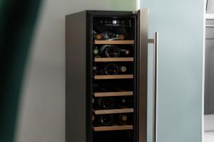 a black cabinet with bottles of wine in it at Maison d'hôtes avec Jacuzzi -Sauna in Montreux-Château