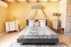 a bedroom with a large bed with a canopy at Maison d'hôtes avec Jacuzzi -Sauna in Montreux-Château