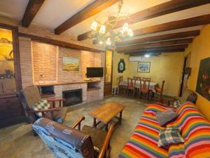 a living room with a couch and a fireplace at Casa Rural La Vid in Cadalso de los Vidrios