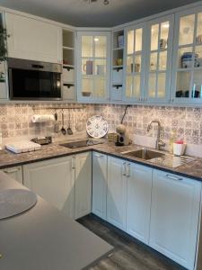 a kitchen with white cabinets and a sink at Balchik Sea View Studio in Balchik