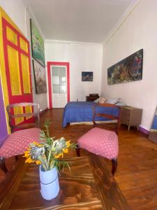a bedroom with a bed and two chairs and a table at La Mancha Art Hostel - Cerro Alegre - Valparaiso in Valparaíso