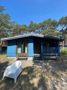 a blue house with a white bench in front of it at Archipelag in Ustka