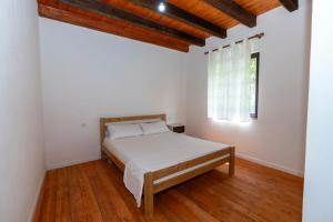 a white bedroom with a bed and a window at Hotel Shen Klementi in Vermosh +38 photos