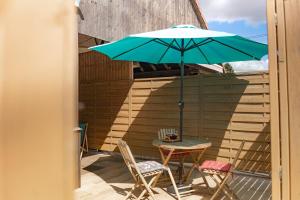 a patio with a table and chairs and an umbrella at Maison d'hôtes avec Jacuzzi -Sauna in Montreux-Château