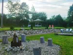 a garden with a rock wall and an umbrella at Rooftop View in Predeluţ