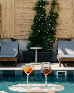 due calici da vino appoggiati su un vassoio accanto a una piscina di Aterna Hotel a Dikili