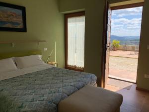 a bedroom with a bed and a view of a patio at Green B&B Urbino Cá del vento in Urbino
