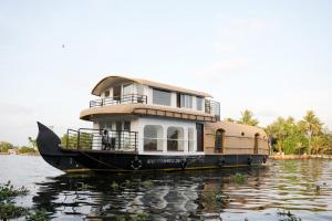 a large house boat sitting on the water at Navora Houseboats in Alleppey