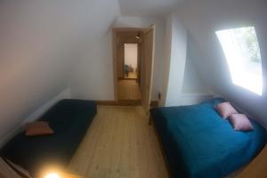 a small room with a blue bed and a window at Chata U3G Kobyly-Mlynky in Kobyly