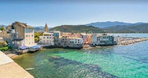a group of buildings on the shore of a body of water at Casa Helena in Saint-Florent