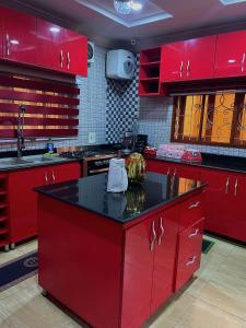 a kitchen with red cabinets and a black counter top at Davic-Mart Apartments Port Harcourt in Umudara