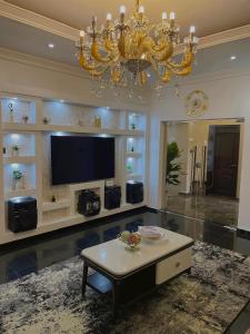 a living room with a chandelier and a coffee table at Davic-Mart Apartments Port Harcourt in Umudara