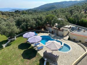 an aerial view of a villa with a swimming pool with umbrellas at Villa in Skiathos in Skiathos