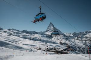 a ski lift flying over a snow covered mountain at Chalet Chrumm in Zermatt