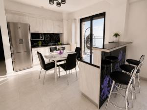 a kitchen with a table and chairs and a refrigerator at SOPHIA LAKE VIEW SUITE in Mamaia